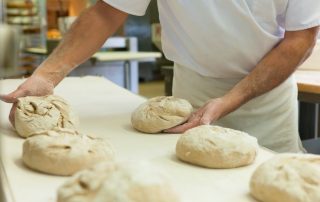baker with fresh bread dough